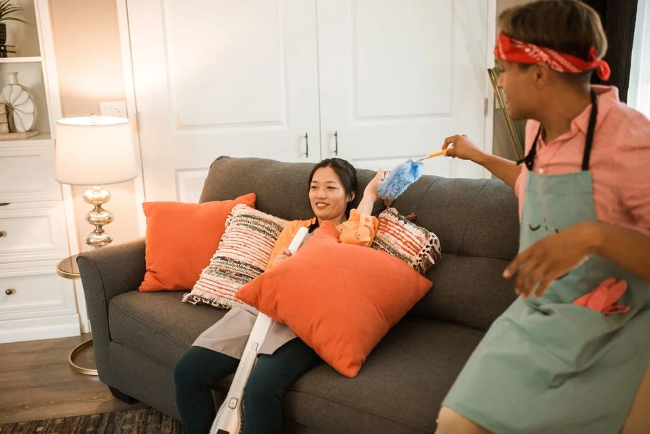 A professional housekeeper organizing pillows in a luxurious hotel room, maintaining service quality.